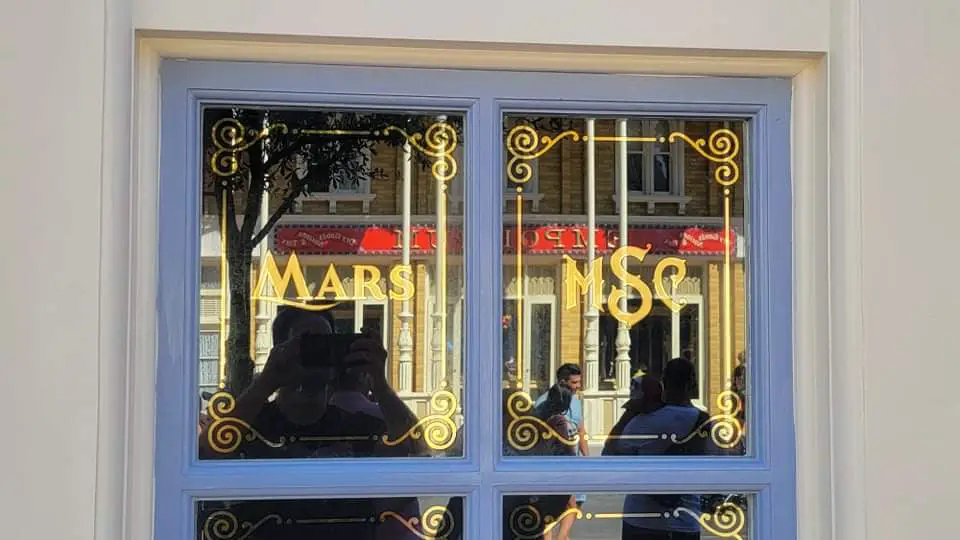 Disney hand painting the windows for Main Street Confectionery