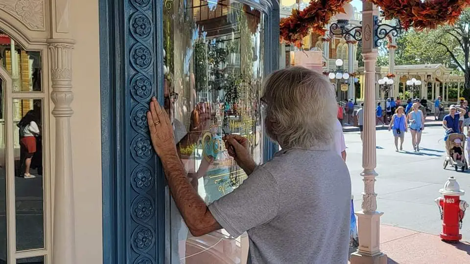 Disney hand painting the windows for Main Street Confectionery
