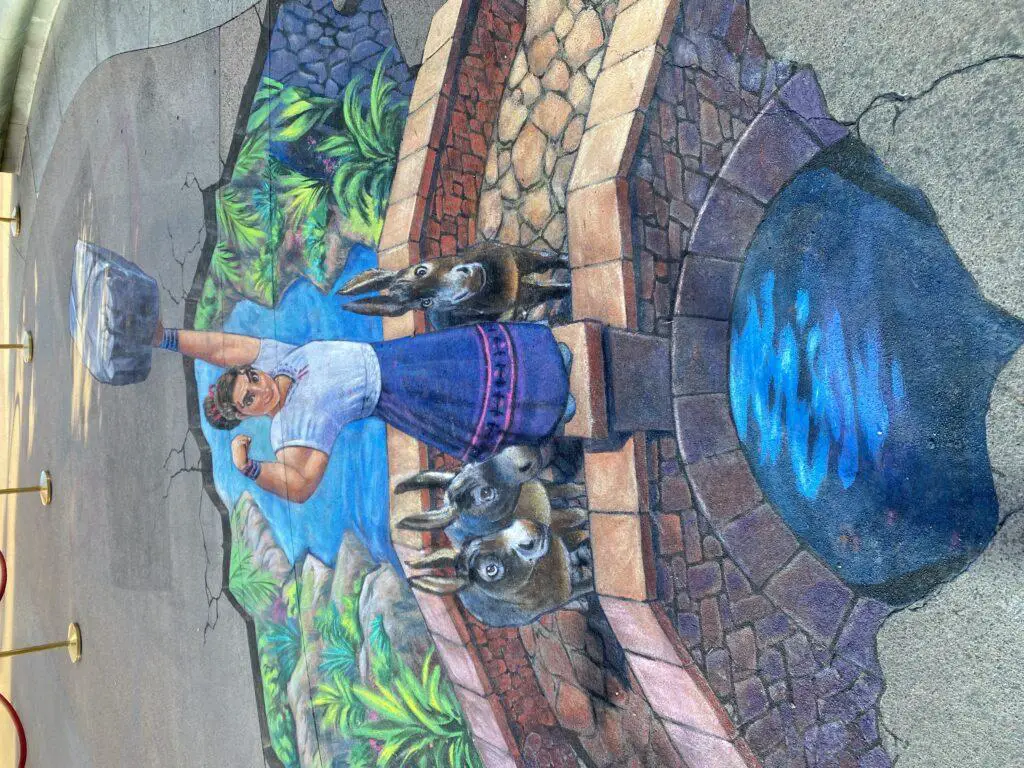 Artist Nate Baranowski does some amazing Encanto chalk art in Downtown Disney